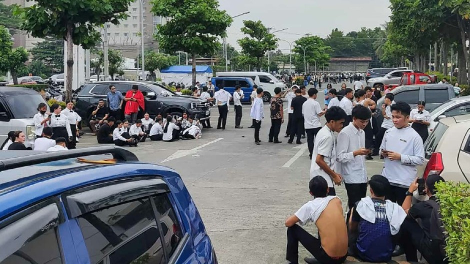 Employees at a shopping mall gather outside the building in Davao City, on the southern island of Mindanao after a 7.4-magnitude earthquake struck off the southern Philippines