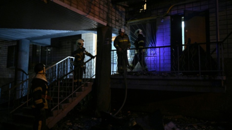 Ukrainian firefighters work in a residential building, damaged during the massive Russian drone and missile strikes