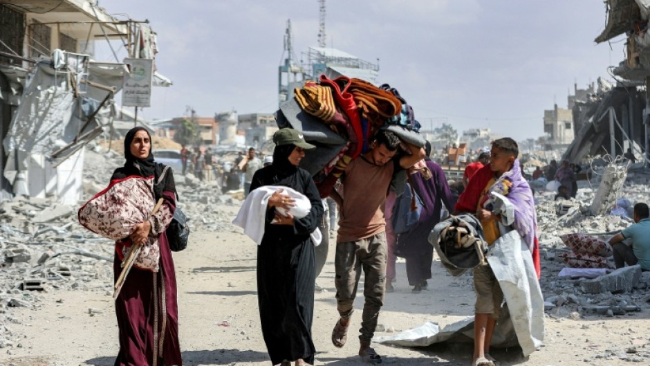 People carried children and belongings as they made their way through the rubble of destroyed buildings to return home