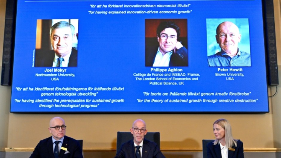 Members of the Swedish Academy of Sciences announce the Nobel economics prize winners, including Peter Howitt (R)
