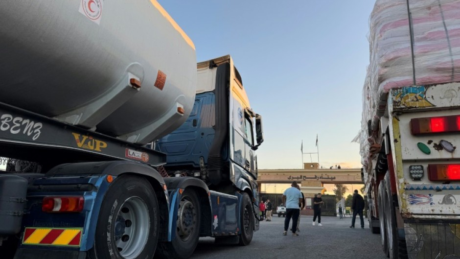 Trucks loaded with humanitarian aid on the Egyptian side of Rafah wait to cross the border