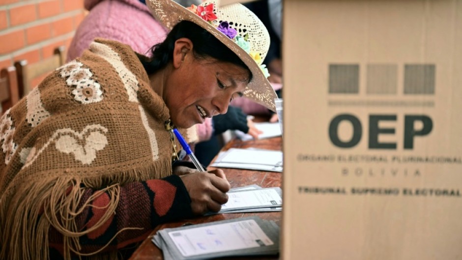 An Aymara woman prepares to cast her vote during the presidential runoff election, in Laja, some 30 km west of La Paz, on October 19, 2025