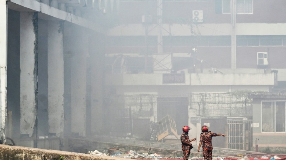 Firefighters inspect the fire-damaged cargo terminal of Hazrat Shahjalal International Airport in Dhaka on October 19, 2025, a day after the blaze