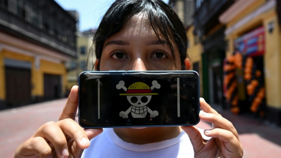 Peruvian law graduate Rosalinda,26, of the Gen Z movement, shows the "One Piece" manga flag on her mobile phone, signifying a demand for deep reforms amid growing insecurity and a decade of political instability