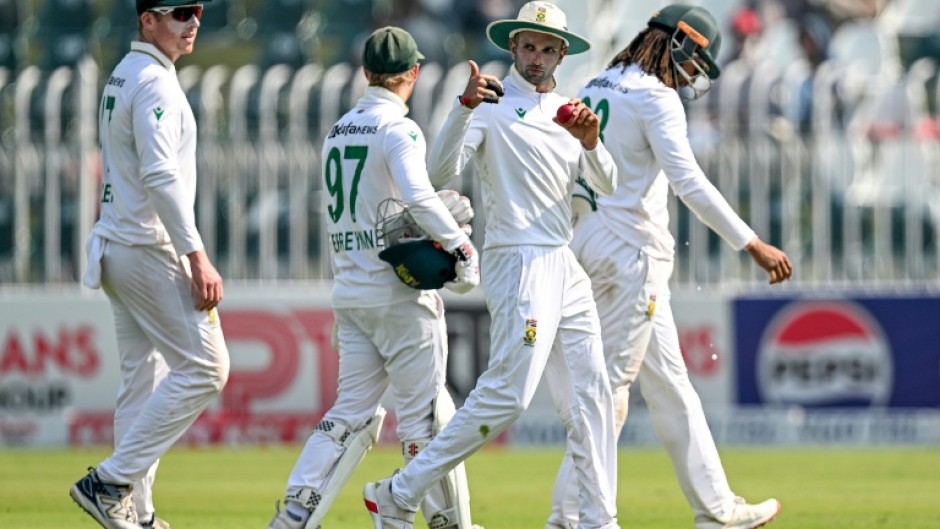 South Africa's Keshav Maharaj (C) gestures as he celebrates after taking his seventh wicket