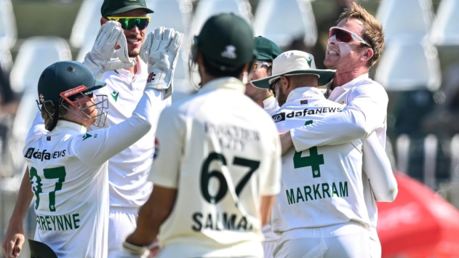 South Africa's Simon Harmer (R) celebrates with teammates after taking the wicket of Pakistan's Noman Ali