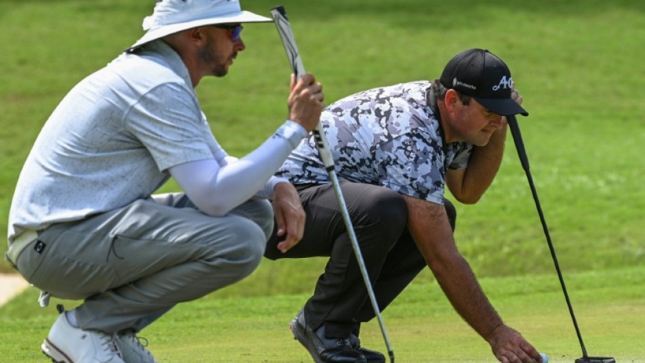 Patrick Reed (right) and fellow American John Catlin line up putts during the first round of the International Series Philippines on Thursday