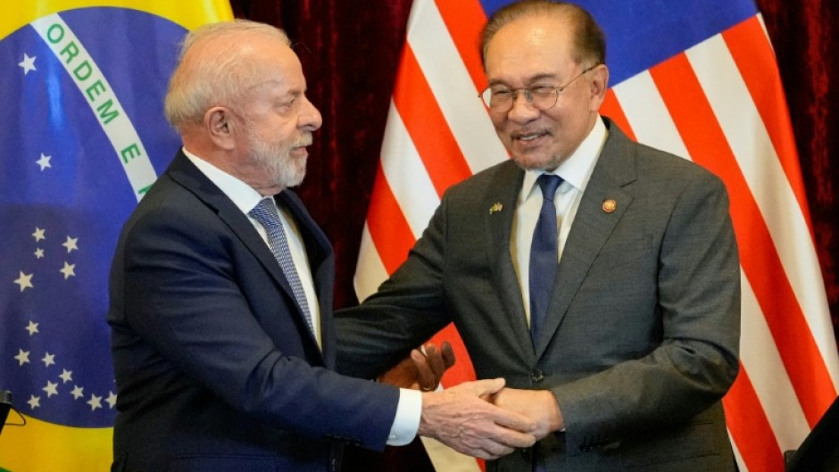 Brazil's President Luiz Inacio Lula da Silva (L) and Malaysia's Prime Minister Anwar Ibrahim shake hands after holding a press conference