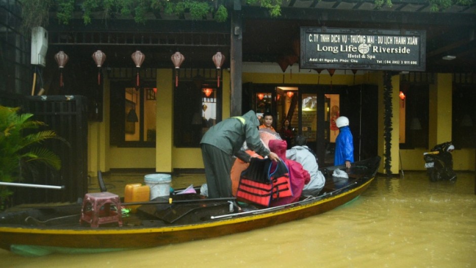People are evacuated from a hotel by boat in flood waters following heavy rains in Hoi An