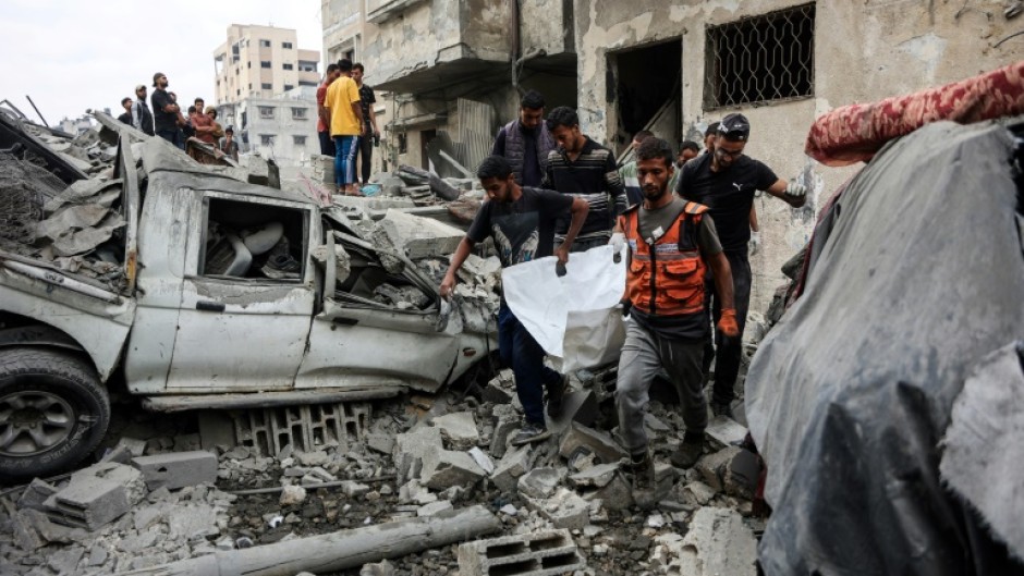Palestinians recover bodies from the rubble after Israel launched another series of air strikes in response to the killing of a soldier