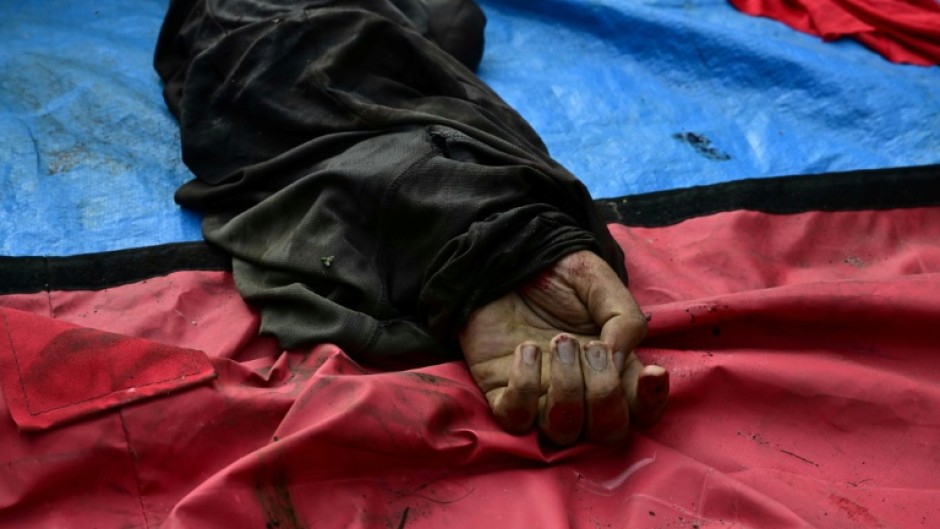 The hand of a dead man is seen among a line of bodies on Sao Lucas Square of the Vila Cruzeiro favela at the Penha complex in Rio de Janeiro, Brazil, on October 29, 2025, in the aftermath of Operacao Contencao (Operation Containment). Residents of a favela in Rio de Janeiro lined up more than 50 bodies at a plaza in their low-income neighborhood on Ocotber 29, a day after the bloodiest police operation in the city's history, AFP reported.