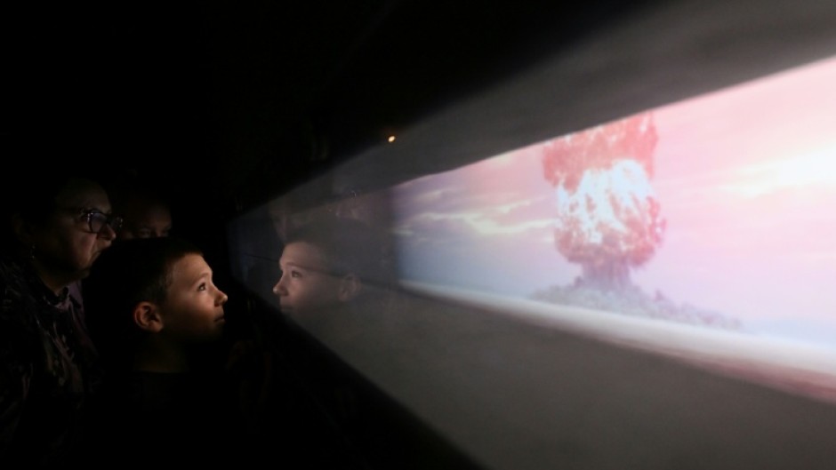 Visitors watch a video of a nuclear bomb test at the All-Russia Exhibition Centre (VDNH) in Moscow in December, 2023