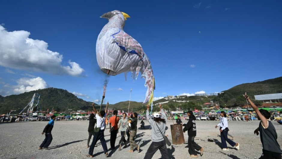 Participants celebrate after they release a hot air balloon during the Tazaungdaing Lighting Festival