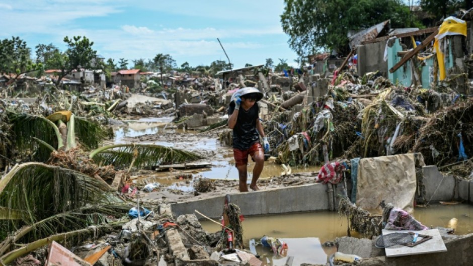 A resident walks among badly damaged houses in the aftermath of Typhoon Kalmaegi in the Philippines' Cebu province