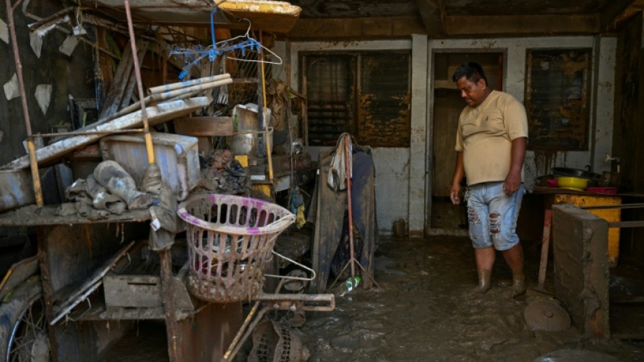 A resident of Cebu province's Liloan town examined belongings covered in mud following the devastation of Typhoon Kalmaegi