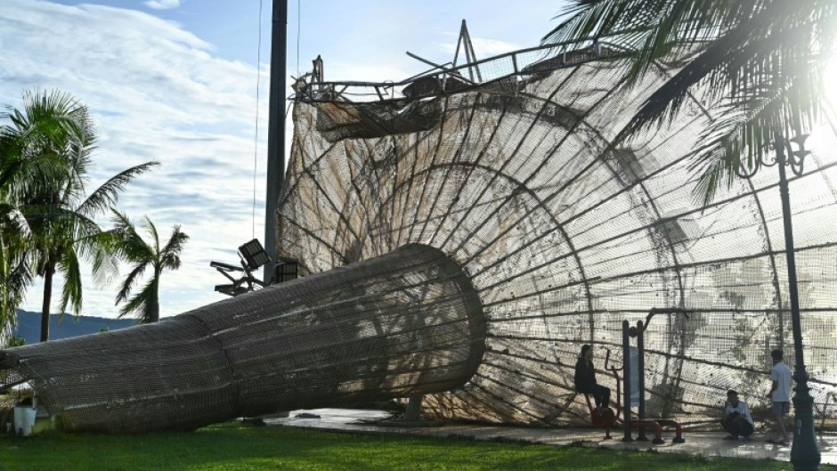 People rest near a structure, damaged by typhoon Kalmaegi, in the Quy Nhon area of Gia Lai province, central Vietnam