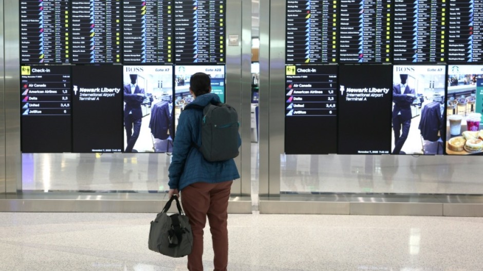 A man looks at the departures board at Newark Liberty International Airport