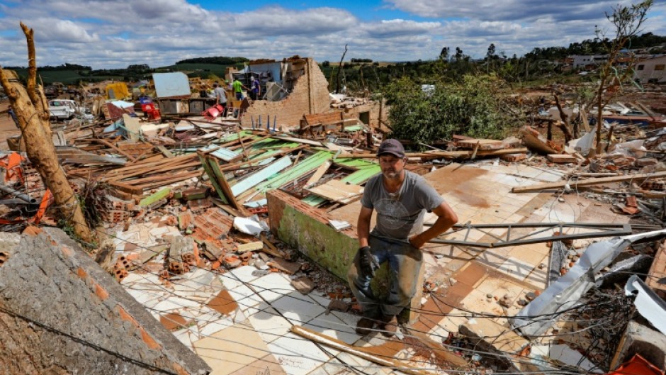 Nereu Sabadini sits on the debris of his house that was destroyed by a tornado in Rio Bonito do Iguaçu, Brazil