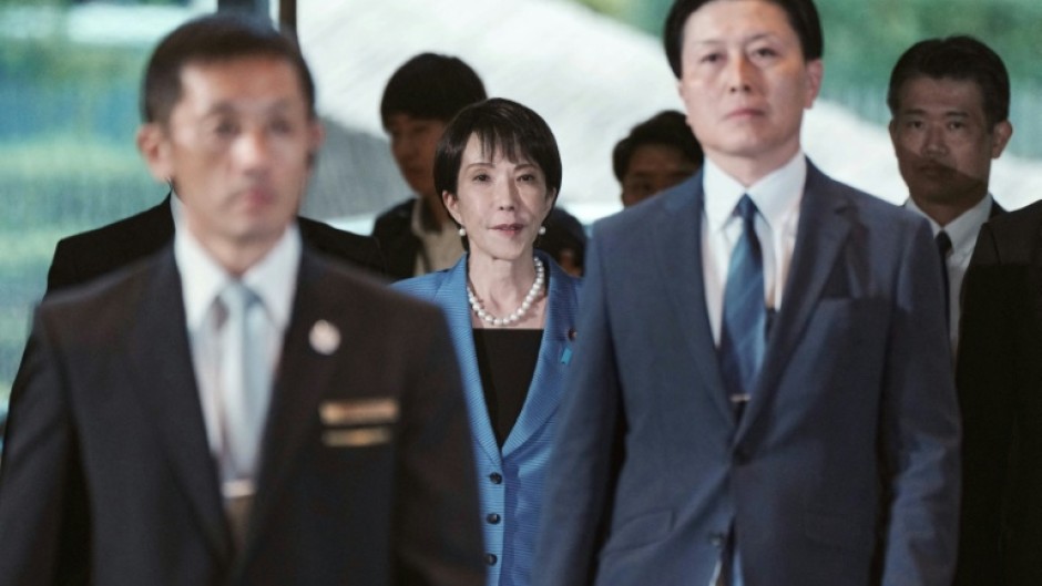 Japan's new Prime Minister Sanae Takaichi (C) arriving at the prime minister's office after being appointed by the parliament, in Tokyo