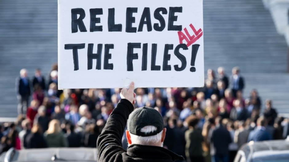 A protester holds a sign related to the release of the Jeffrey Epstein case files outside the US Capitol