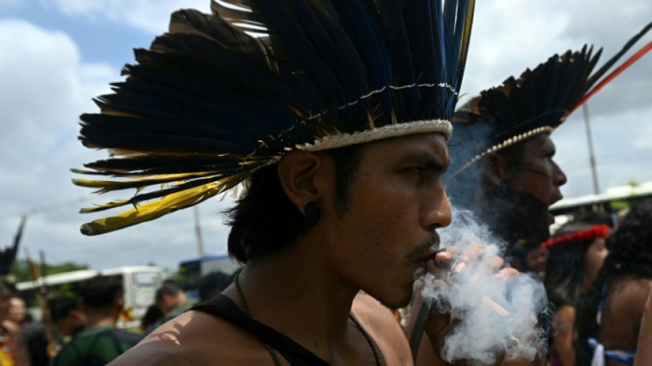 A Munduruku Indigenous man of the Ipereg Ayu movement smokes during a protest outside the COP30 UN Climate Change Conference in Belem