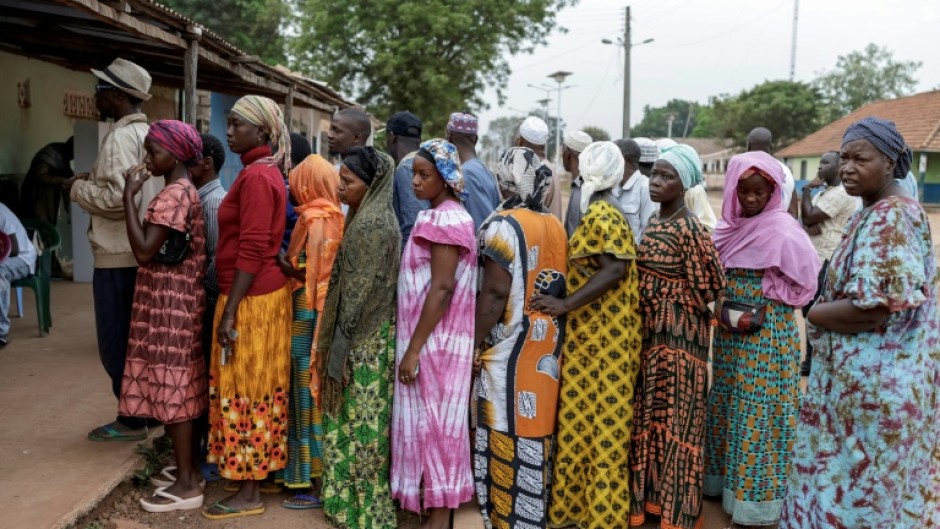 Voters queue outside a polling station