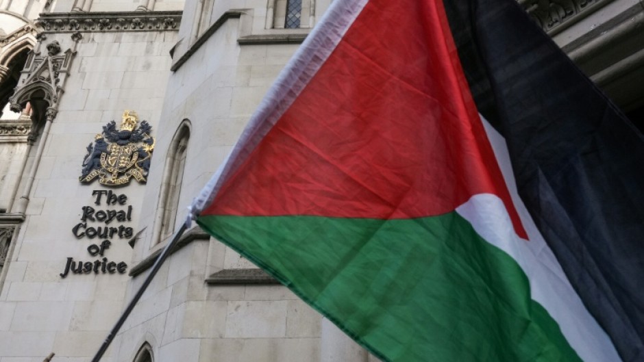 A Palestinian flag held up by protesters outside the London appeal court where the Palestine Action case is being heard