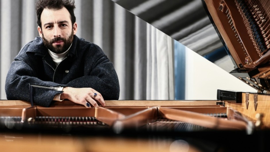 Julien Cohen can be seen leading the troupe of 30 performers on a grand piano