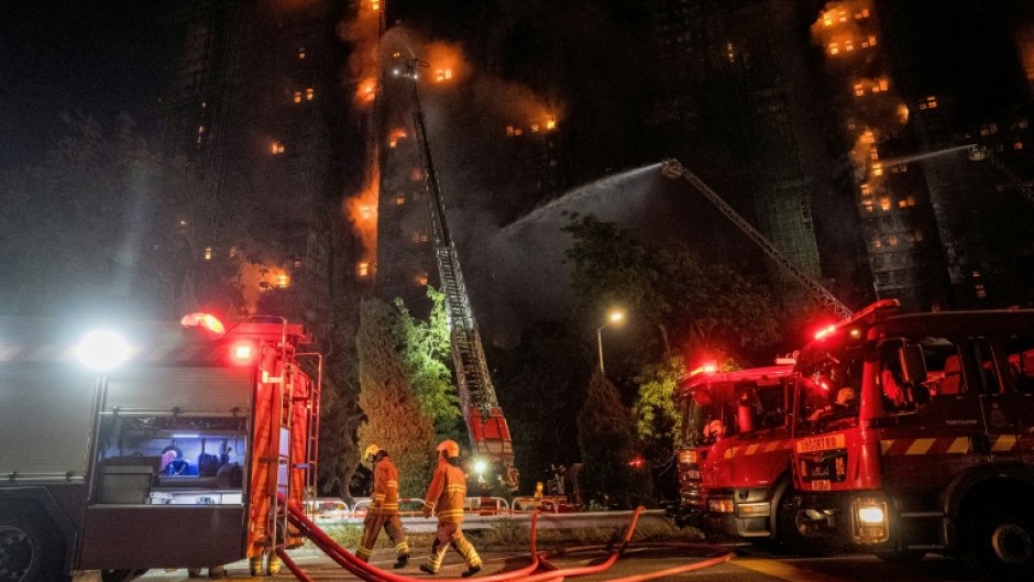 Firefighters spray water on flames as a major fire engulfs several apartment blocks at the Wang Fuk Court residential estate in Hong Kong's Tai Po district