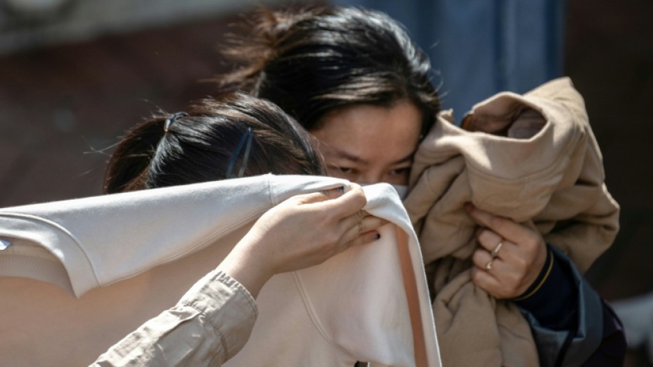 People mourn after identifying bodies in the aftermath of a major fire that swept through several apartment blocks at the Wang Fuk Court residential estate in Hong Kong's Tai Po district