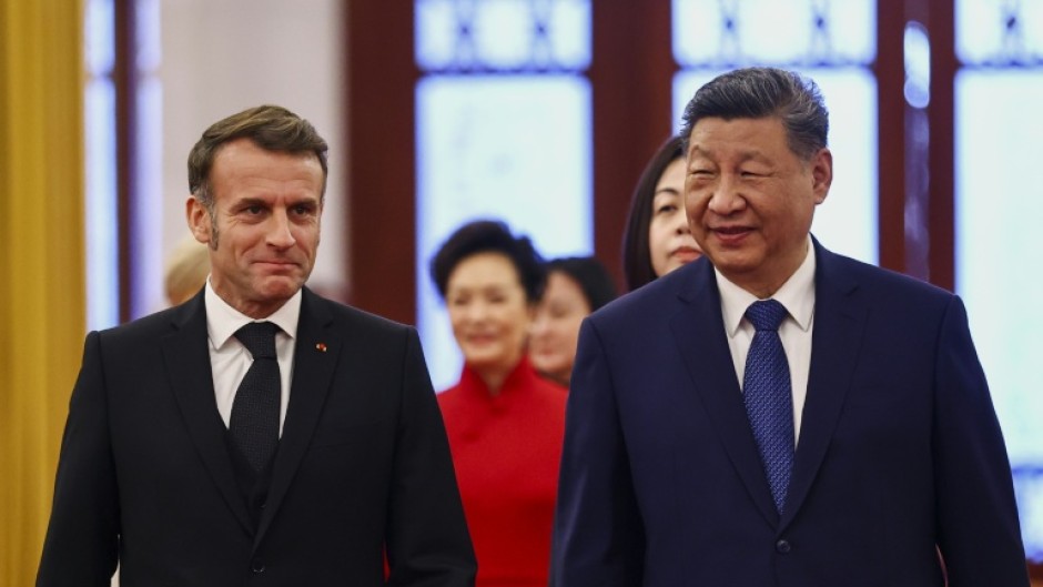 China's President Xi Jinping (R) and France's President Emmanuel Macron attend a welcome ceremony at the Great Hall of the People in Beijing