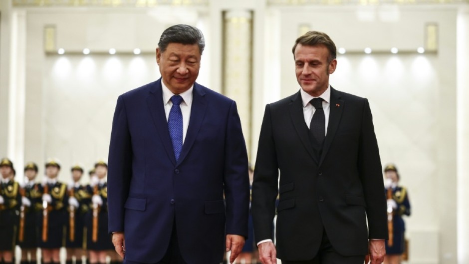 China's President Xi Jinping (L) and France's President Emmanuel Macron attend a welcome ceremony at the Great Hall of the People in Beijing on December 4, 2025