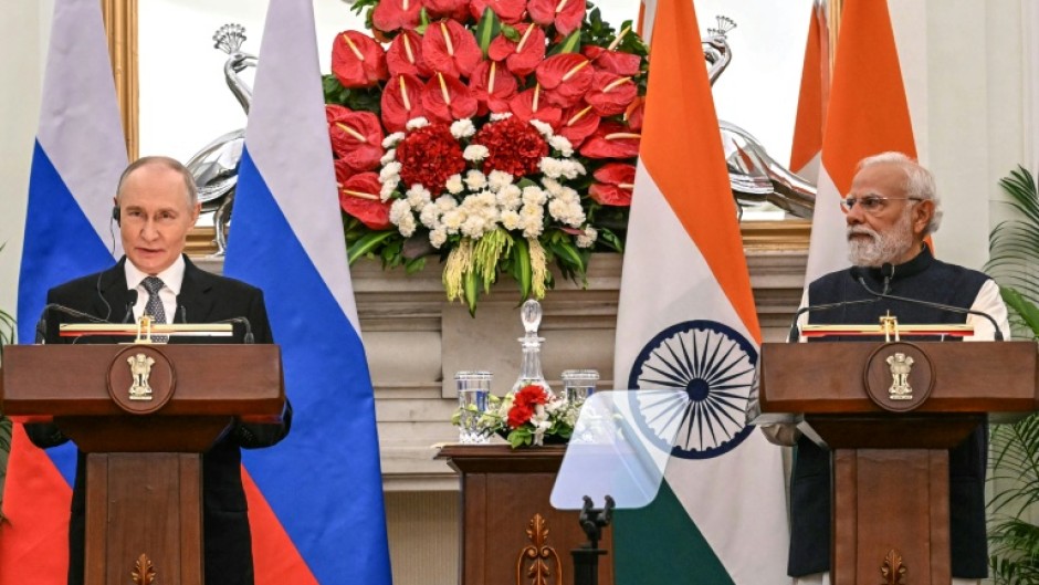 Russia's President Vladimir Putin (L) speaks as India's Prime Minister Narendra Modi listens during their joint press statements after their meeting at the Hyderabad House in New Delhi on December 5, 2025