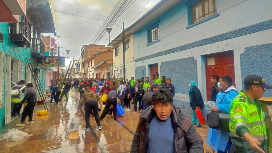 Police and residents try to extinguish a fire in a restaurant in the Peruvian town of Huancane that killed 10 students