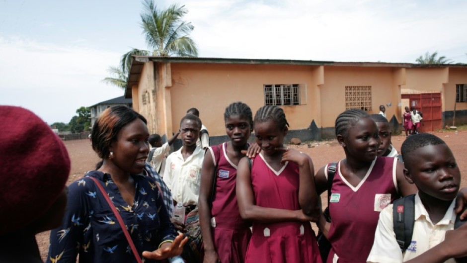 Sexual health activist Fatou Esther Jusu interacts with school girls at a secondary school in Freetown in October 2025
