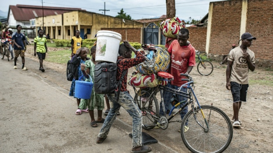 Lines of civilians crossed the border, watched by Rwandan police