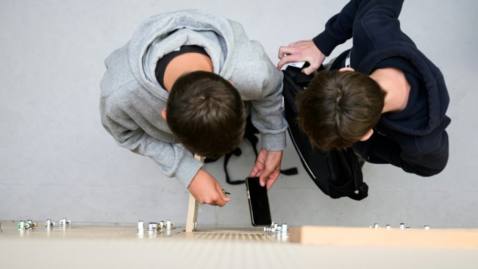 Students place their phones in lockers after switching them off at a highschool in Lorient