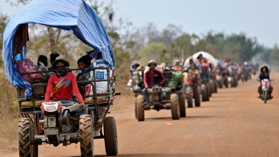 Displaced residents evacuate with their belongings along the Cambodia-Thailand border in Cambodia's Siem Reap province