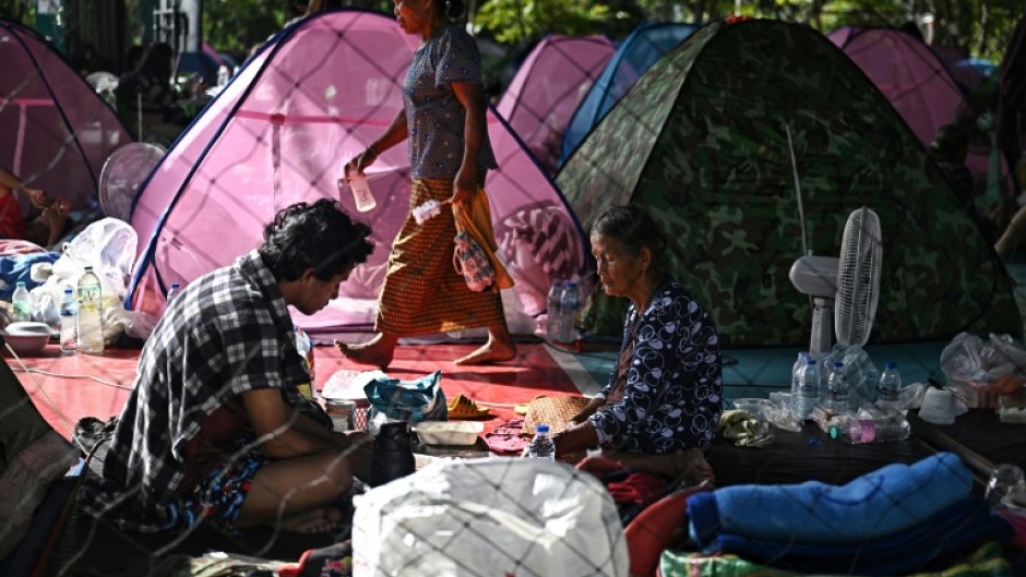 A security guard inspects an evacuated house that was hit by Cambodian artillery in Thailand's Surin province