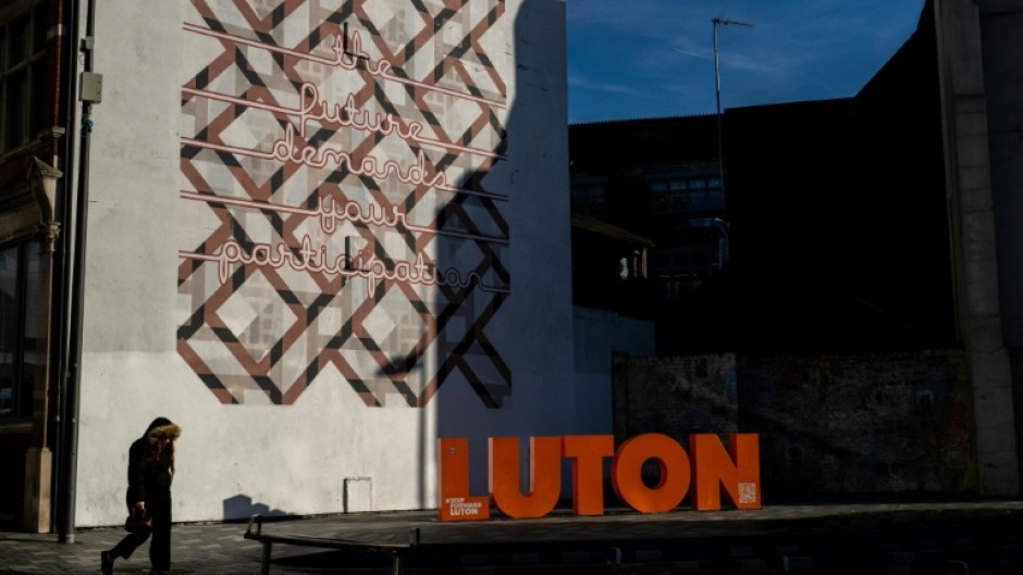 Pedestrians walk through the town centre in Luton, north of London, one of Britain's most diverse towns, with a non-white majority and an estimated 150 languages and dialects spoken on its streets and its places of worship