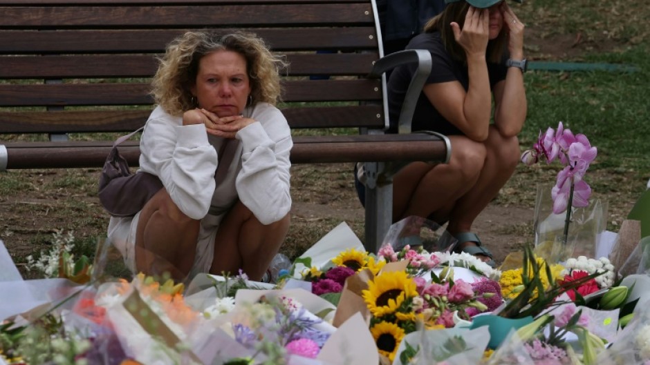 Mourners gather around floral tributes at the Bondi Pavilion in Sydney in memory of victims of the Bondi Beach shooting.