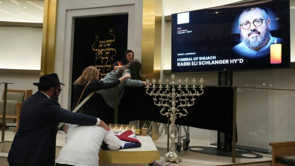 Many mourners were overcome with grief as they saw the black casket carrying rabbi Eli Schlanger.