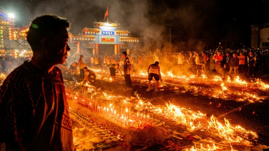 People burn incense sticks while offering prayers during the decennial Jiao Festival of Kam Tin