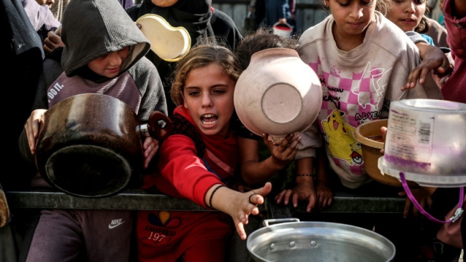 Displaced Palestinian children waited for food at a shelter in Nuseirat, Gaza, in November 2025