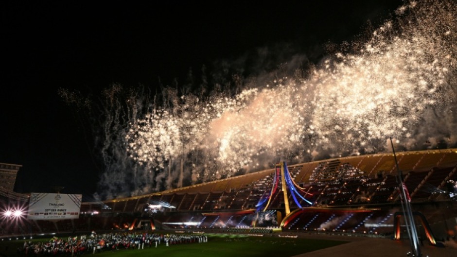 Athletes watch fireworks during the closing ceremony of the 33rd Southeast Asian Games in Bangkok, with host Thailand topping the medal charts with 233 golds