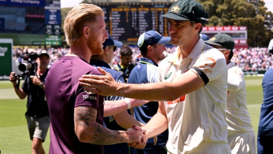 Australia's Pat Cummins (R) shakes hands with England captain Ben Stokes (L) after the third Adelaide Test