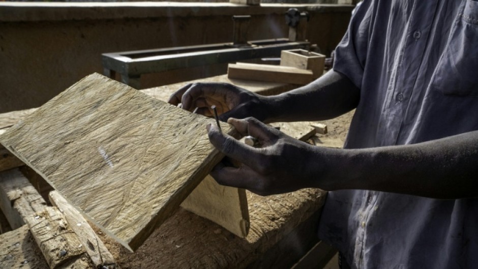 A man works as a carpenter in a workshop dedicated to training former child soldiers in the Democratic Republic of Congo