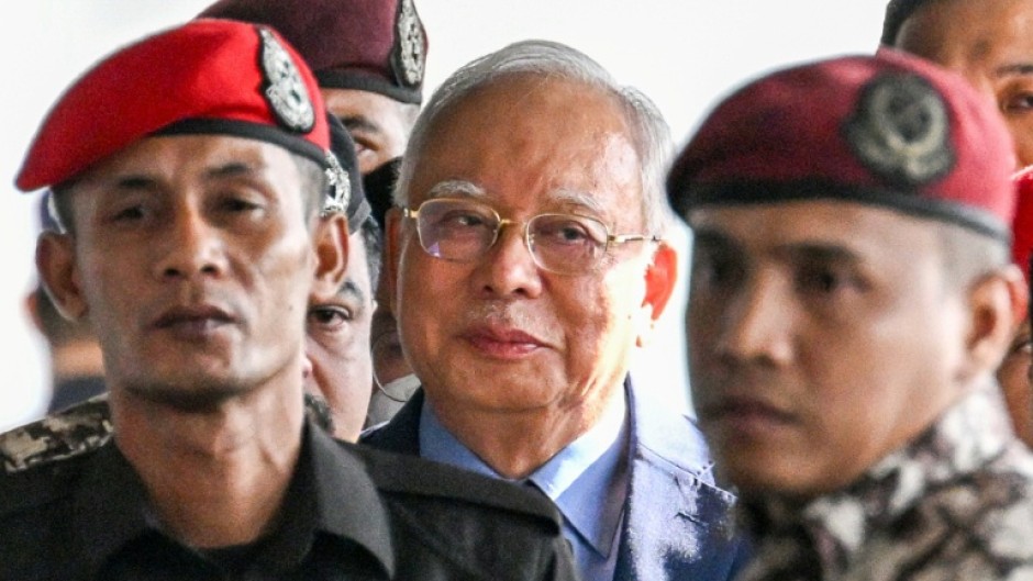 Former Malaysian prime minister Najib Razak (C) was found guilty in the 1MDB financial scandal