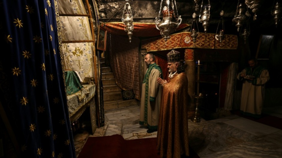 Members of the clergy pray inside the Grotto, believed to be the birthplace of Jesus Christ, in the Church of the Nativity in Bethlehem