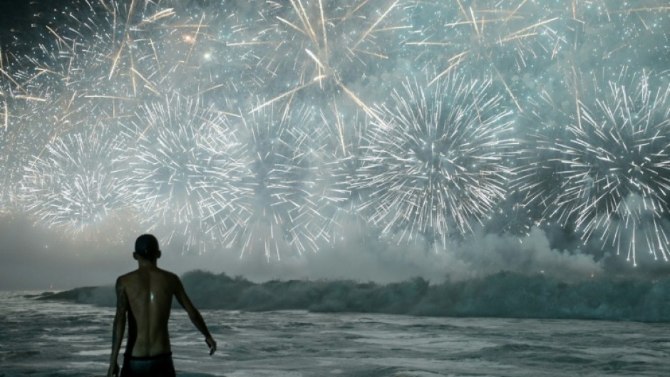 A man celebrates as he watches the traditional New Year's fireworks from the water at Copacabana Beach in Rio de Janeiro, Brazil, on January 1, 2026